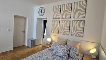 Tabla de planchar con plancha, internet y ropa de cama