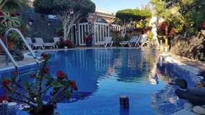 A swimming pool with lounge chairs and a gazebo. - Relax in El Médano's Modern Sea View Apartment (Granadilla de Abona)