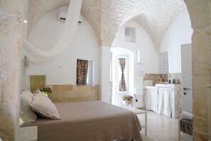 Une chambre avec un lit, une petite table et une vue sur la cuisine.