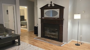 A living room with a fireplace, a sofa, a coffee table, and a floor lamp.