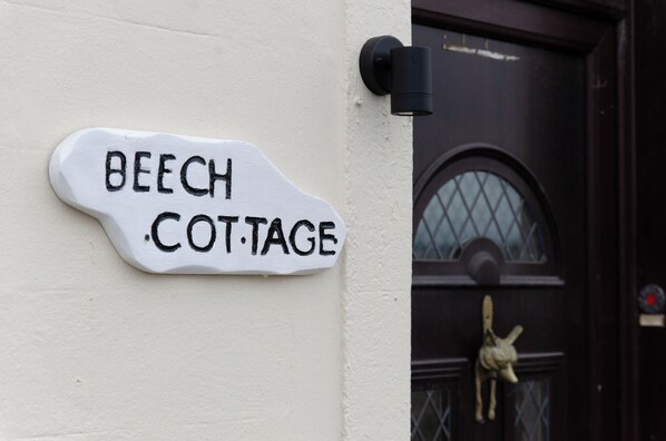 A white house sign that reads "BEECH COTTAGE" mounted on a wall. - Cosy Cottage in Armadale West Lothian. (Armadale)