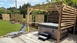 A wooden pergola with a built-in hot tub, a lounge chair, and a small bench. - Nature & jacuzzi, near Sancerre, Guedelon, Lac de Bourdon, St Fargeau, Pouilly (Cosne-Cours-sur-Loire)