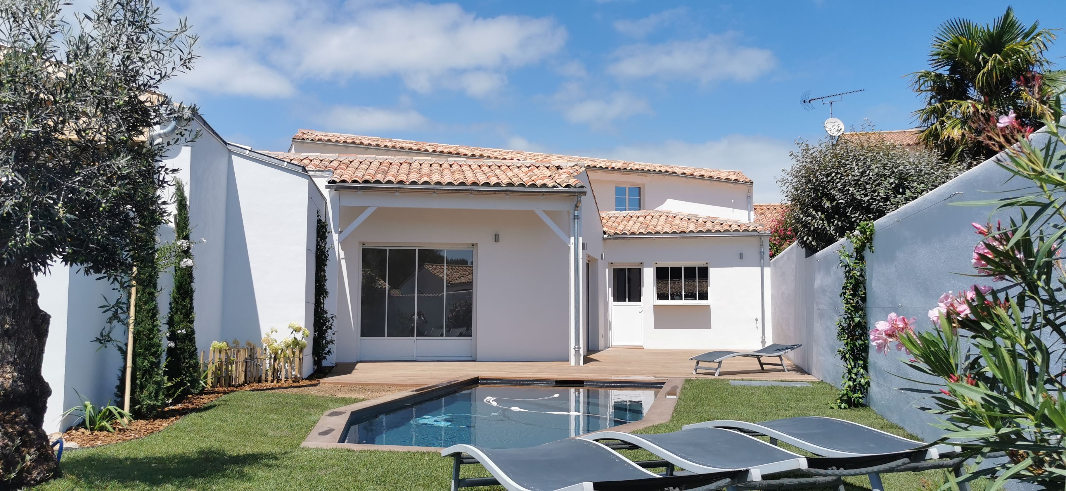 A residential property with a swimming pool, a covered patio, and a white exterior.