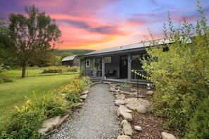 A rustic building with a number '4691' on the side, surrounded by a gravel path and greenery. - Finger Lakes Cabin | Close to All Top Attractions (Beaver Dams)