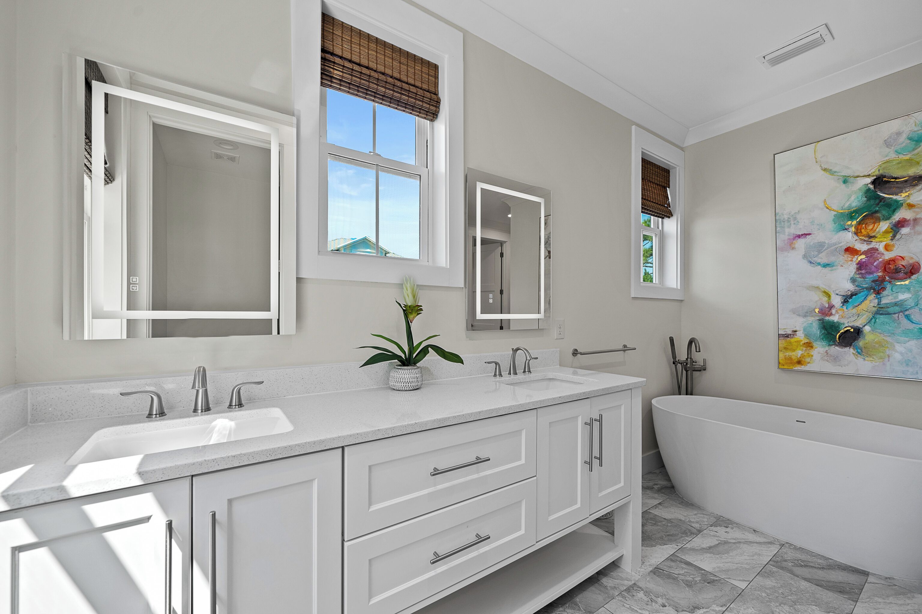 Un bagno moderno con una vasca freestanding, un mobile lavabo doppio e un grande specchio sopra il mobile.