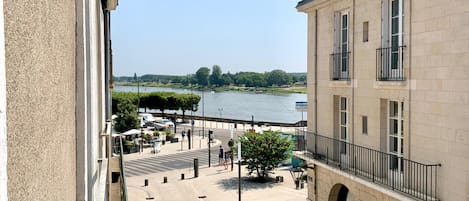 A riverside view with a building, a pedestrian area, and a sign reading 'SOCIETE GENERALE'.