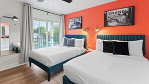 A hotel room with two beds, a large window with a view, and artwork on the walls.