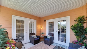 A covered porch with two wicker chairs, a small table, and a potted plant. - 5 Mi to Wdw: Resort-style Condo w/ Pool Access (Kissimmee)