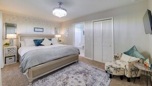 A bedroom with a large bed, a nightstand, a chair, a small table, a ceiling fan, and a closet. - 5 Mi to Wdw: Resort-style Condo w/ Pool Access (Kissimmee)