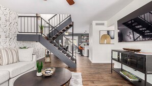 A modern living room with a staircase, a sofa, a coffee table, and a TV. - Walk to Old Town & Giants Stadium! Unit w/ Pool (Scottsdale)