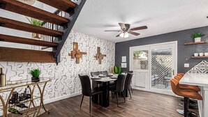 A dining area with a wooden staircase, a ceiling fan, and a patterned wall. - Walk to Old Town & Giants Stadium! Unit w/ Pool (Scottsdale)