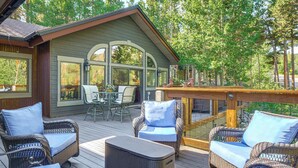 Une terrasse couverte, aménagée avec des meubles en osier et un coin repas.