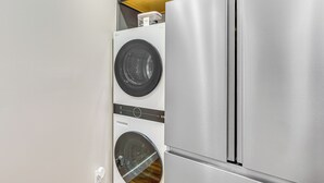 A compact kitchen with a stainless steel refrigerator and a front-loading washing machine. - Hike & Ski: Condo 8 Mi to Dtwn Salt Lake City! (Salt Lake City)