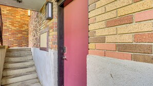 A red door with a metal handle, a brick wall, and a concrete staircase. - Hike & Ski: Condo 8 Mi to Dtwn Salt Lake City! (Salt Lake City)