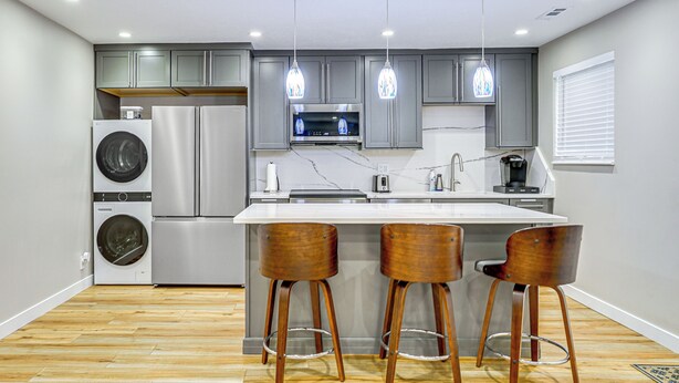 A modern kitchen with stainless steel appliances, wooden bar stools, and pendant lighting. - Hike & Ski: Condo 8 Mi to Dtwn Salt Lake City! (Salt Lake City)