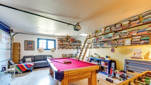 A cozy living room with a pool table, a sofa, and a bookshelf filled with books. - Trail Access, Hot Tub: Lakefront Boulder Retreat! (Boulder)