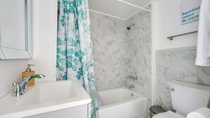 A bathroom with a white sink, a bathtub, a shower, and a toilet. - Clean Birmingham Home Fenced Yard Bessemer (Bessemer)