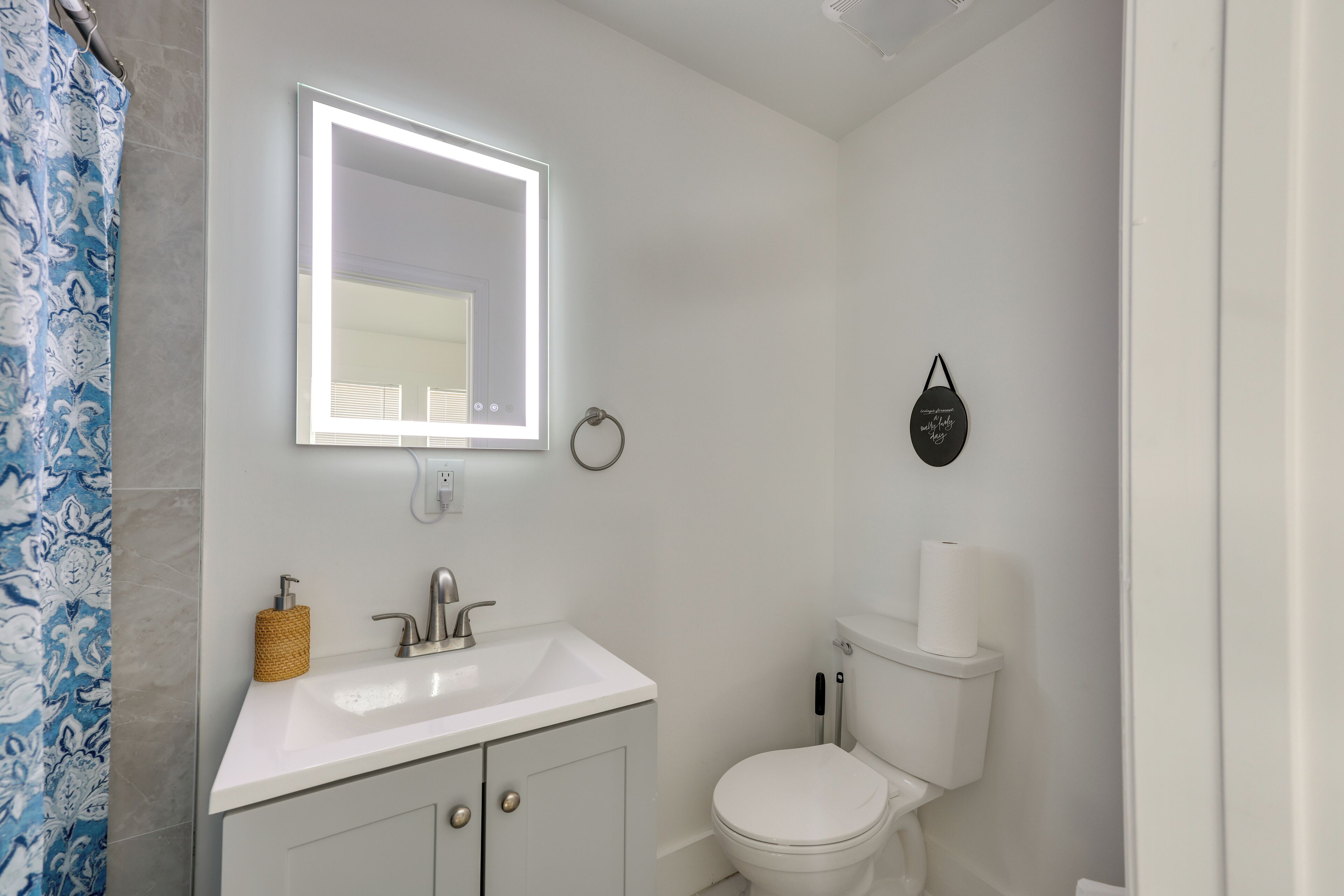 Een badkamer met een witte wastafel, spiegel en toilet.