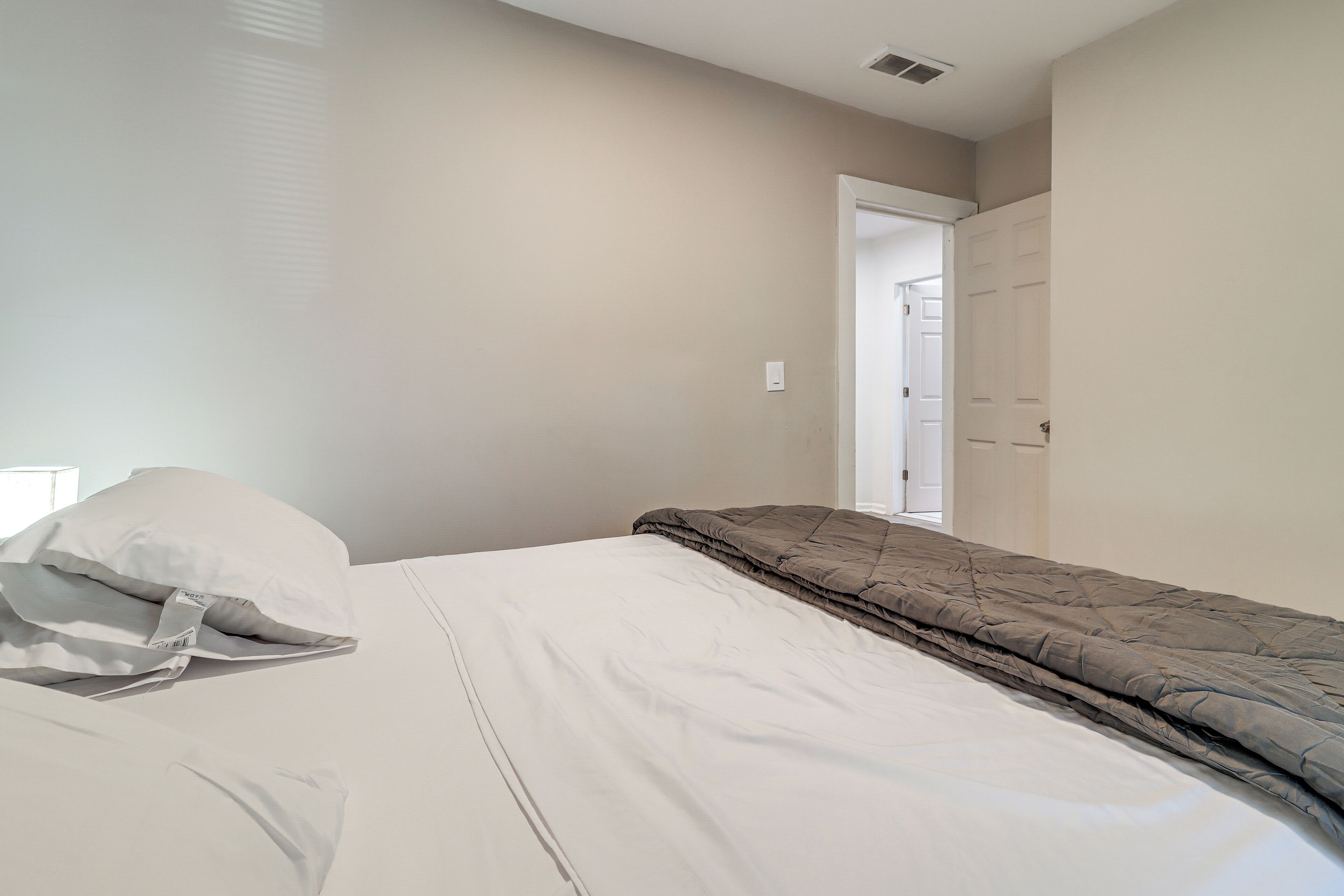 Une chambre à coucher avec un lit, un oreiller et une porte donnant sur une autre pièce.