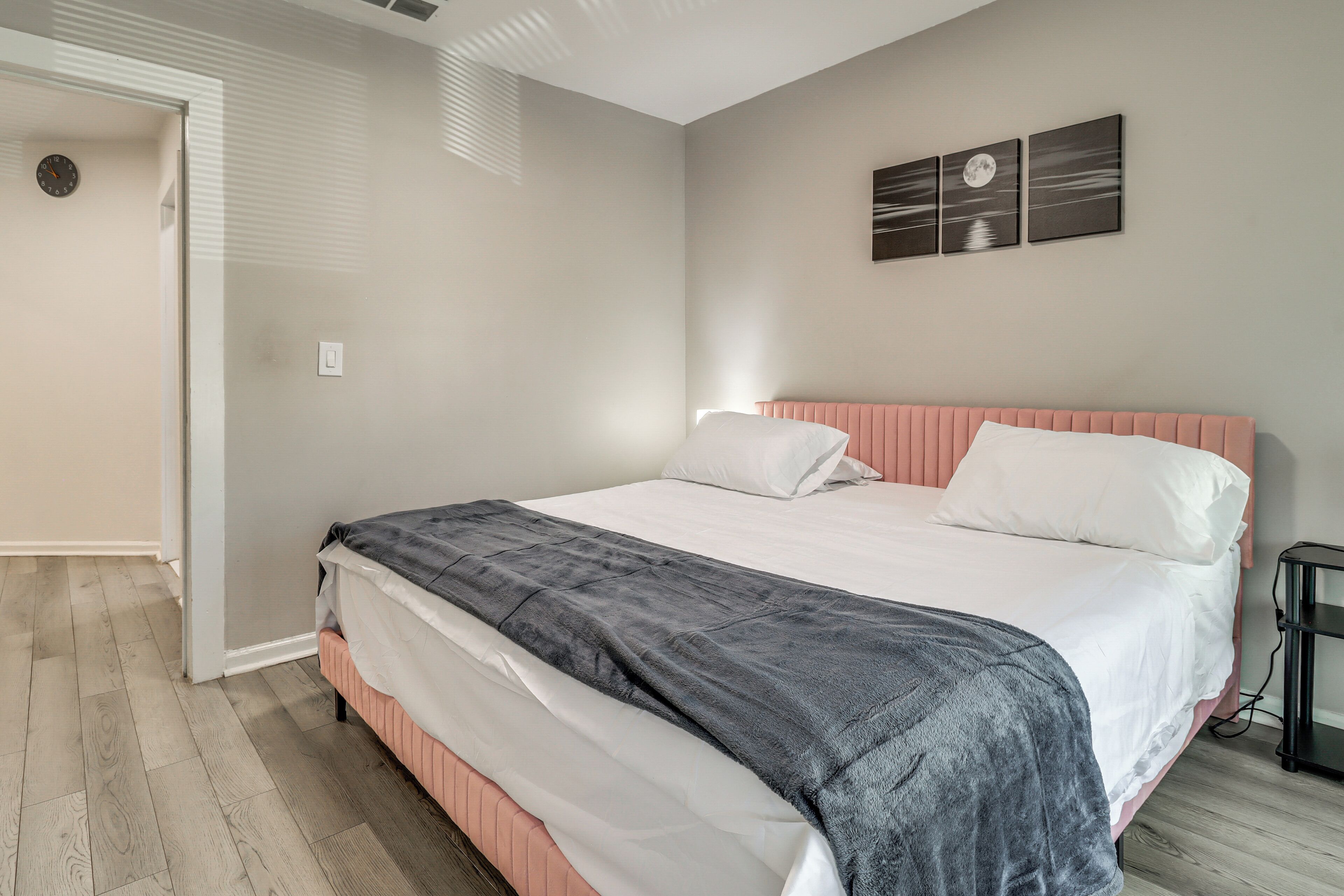 Ein Schlafzimmer mit einem Bett, einem Nachttisch und einer Wanduhr.