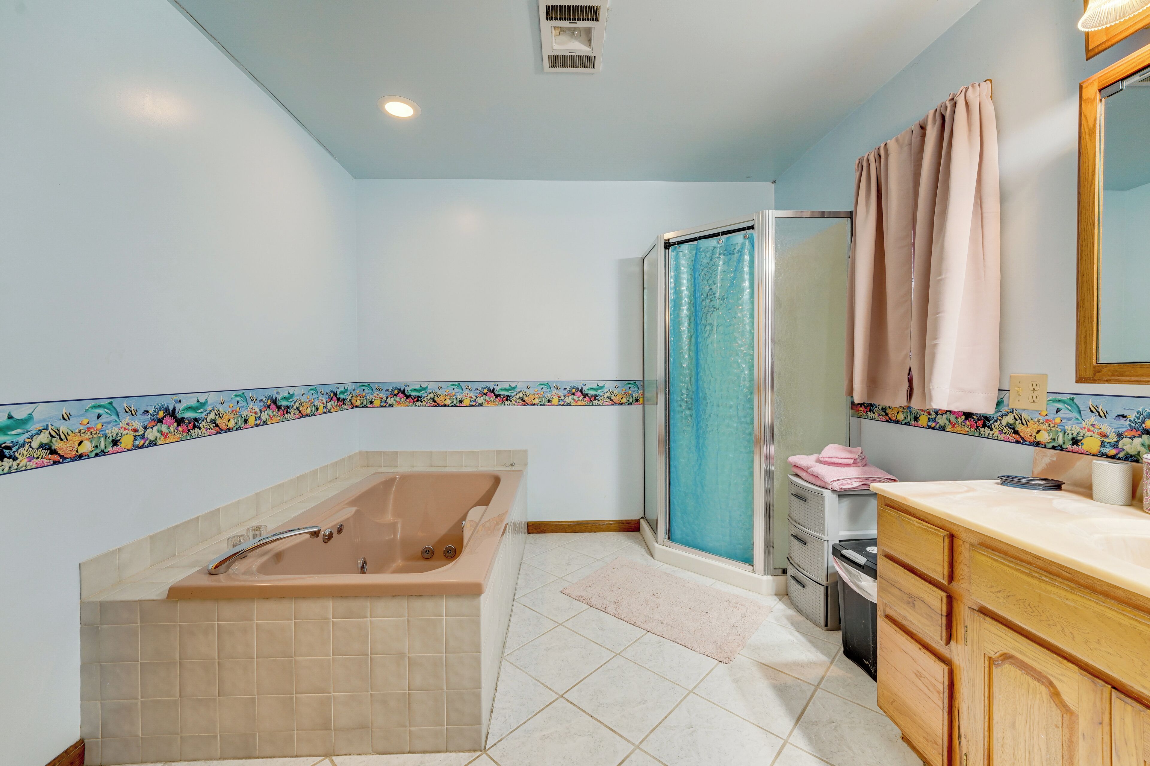 A bathroom with a bathtub, shower, vanity, and a tiled floor.