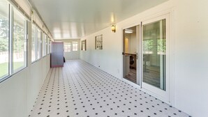 A corridor with patterned flooring, large windows, and a door leading to an outdoor area. - Hemet Retreat w/ Peak Views + 2 Saunas (Hemet)