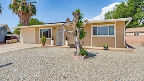 A single-story house with a beige exterior, a front garage, and a gravel driveway. - Hemet Retreat w/ Peak Views + 2 Saunas (Hemet)