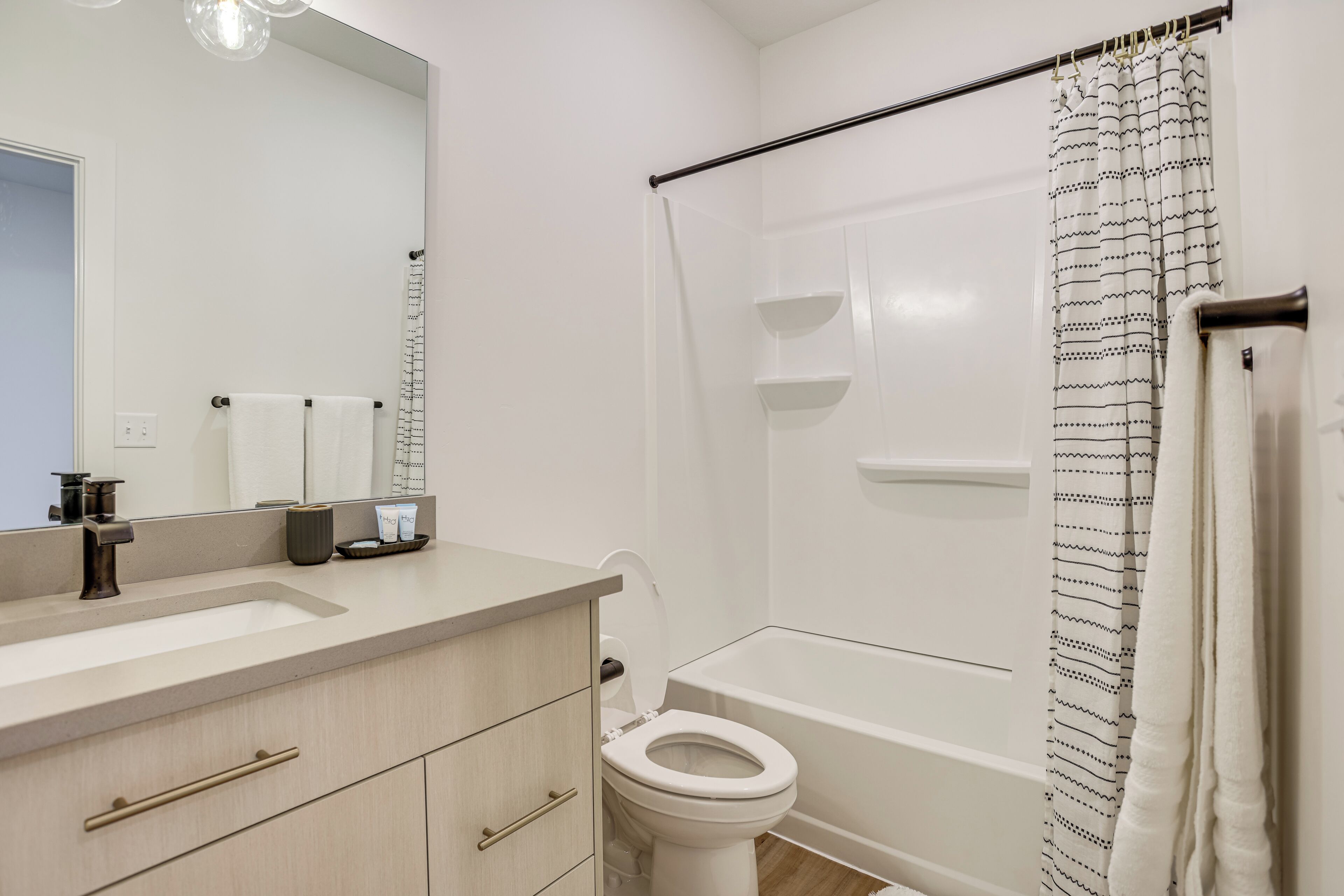 Une salle de bain moderne avec un lavabo, des toilettes et une baignoire.