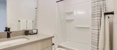 Une salle de bain moderne avec un lavabo, des toilettes et une baignoire.