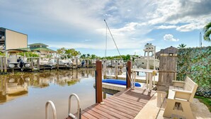 A marina with docked boats, a wooden deck, and a small building with a green roof. - 'the Waterfront Cottage' w/ Dock in Goodland! (Goodland)