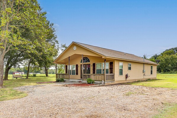 A single-story house with a porch, a front door, and a satellite dish. - 3 Mi to Arkansas River: Rural Family Home w/ Yard (Spiro)