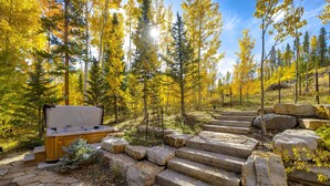 A stone staircase leading up to a wooden deck with a hot tub. - Back Road Bliss - Beautiful Frisco Home (Frisco)