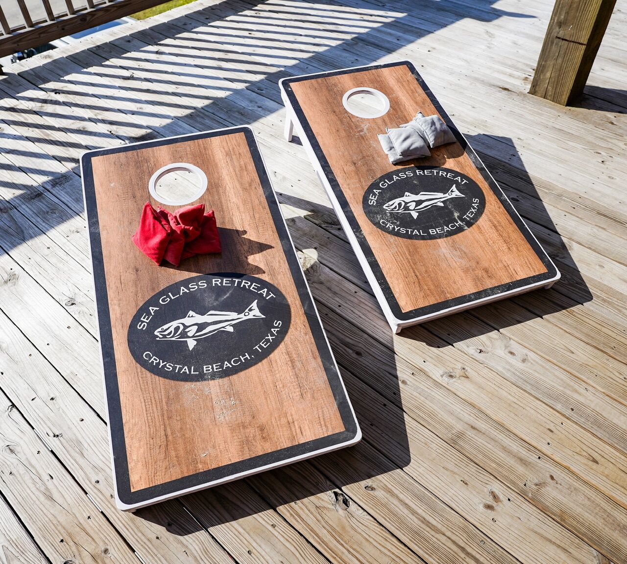 Dos tablas de remo de madera con logotipos y texto que indican que son para un Retiro de Cristal Marino en Crystal Beach, Texas.