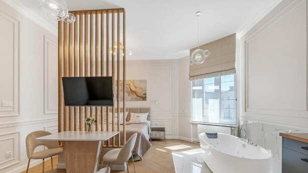 Un bagno moderno con una vasca da bagno indipendente, un mobile lavabo e un’ampia finestra che permette l’ingresso di luce naturale.