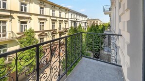Un balcone con ringhiere nere elaborate che si affaccia su una fila di edifici.