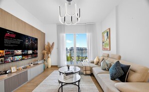 Apartamento estándar, vistas al mar | Sala de estar | Smart TV de 65 pulgadas con canales digitales, Netflix