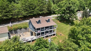 A two-story building with a flat roof, a balcony, and a flag.