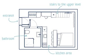 A floor plan of a hotel room with an entrance, bathroom, kitchen area, and stairs to the upper level.