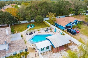Ein Wohnhaus mit Pool, umzäunter Garten und Garage.
