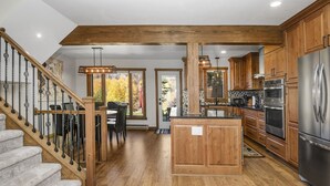 Eine geräumige Küche mit Holzausstattung, einem Edelstahlkühlschrank und einer Holzinsel.