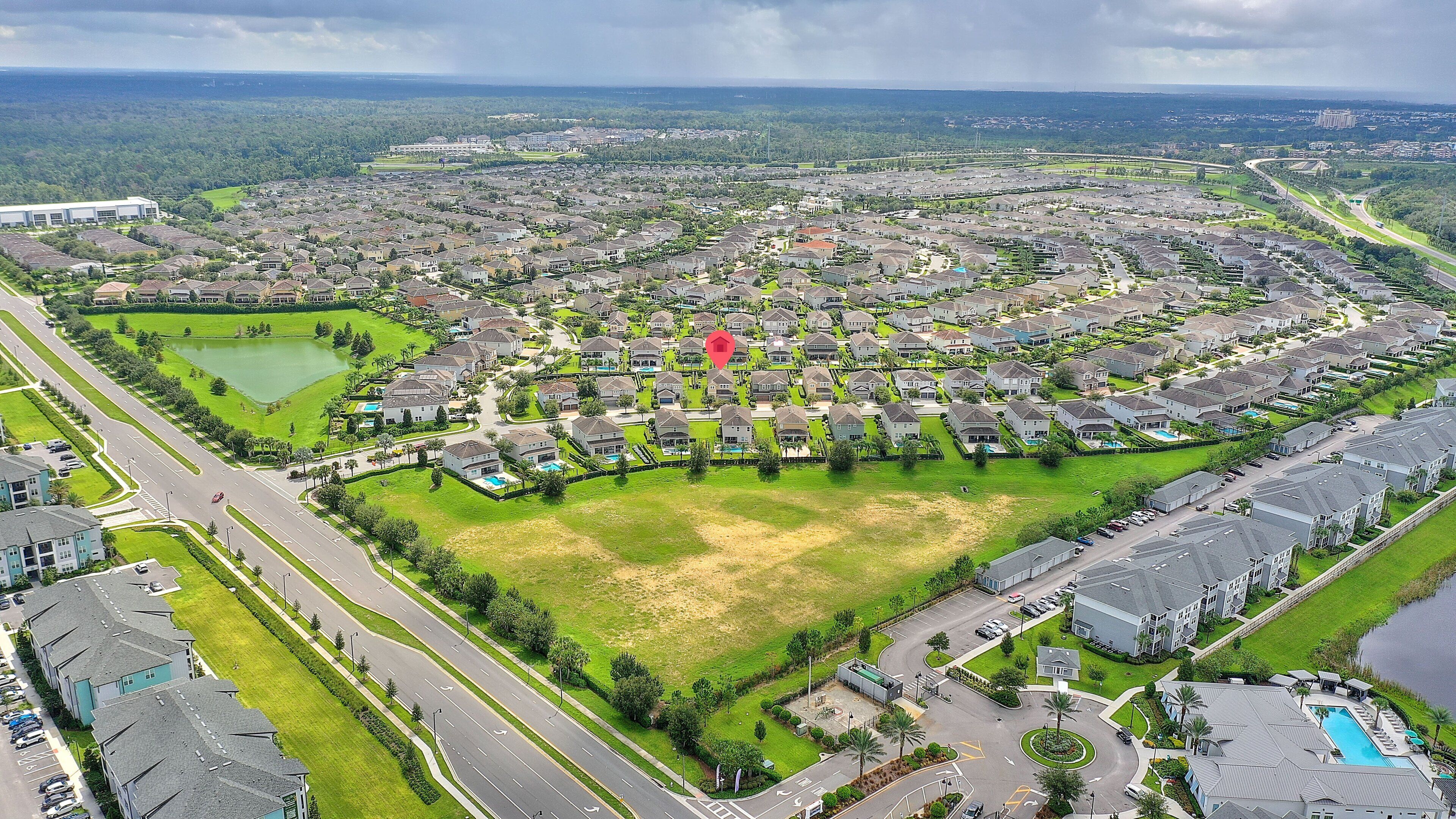 Un quartier résidentiel doté d’un vaste espace vert central, de nombreuses rues et d’un plan d’eau.