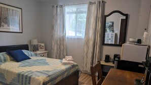 A bedroom with a bed, a desk, a chair, a lamp, and a mirror. - Cozy Private Room, Very close to Hospital, College & University, Free Parking. (Peterborough)