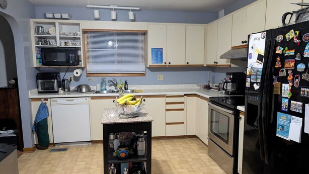 A kitchen with white cabinets, a microwave, a stove, and a refrigerator. There is a window with blinds and a sink. - Cozy Private Room, Very close to Hospital, College & University, Free Parking. (Peterborough)