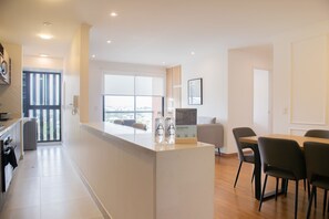 A modern kitchen with a central island, a dining area with chairs, and a large window offering a city view. - w Inviting 2BR w Balcony in Miraflores (Lima)