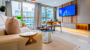 Una sala de estar moderna con un sofá, una mesa de centro y un televisor montado en la pared.