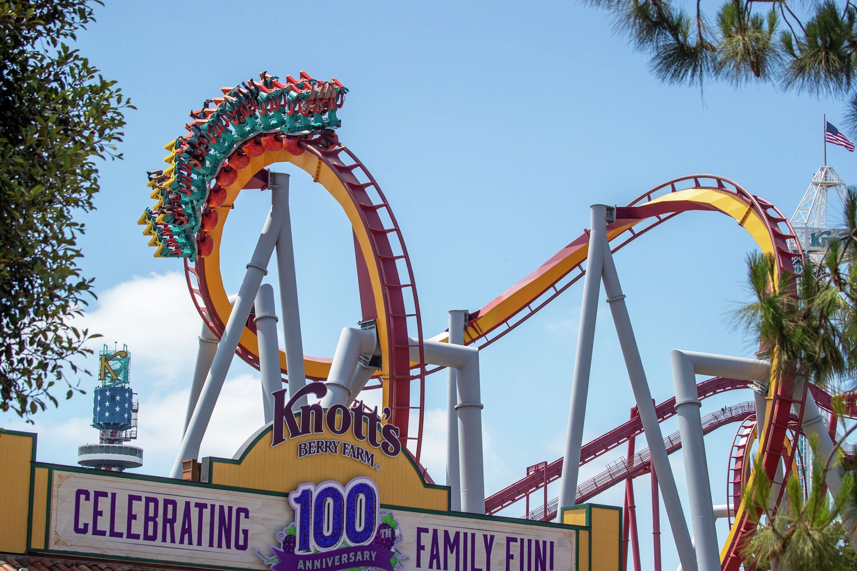A roller coaster at Knott's Berry Farm with a sign celebrating its 100th anniversary.