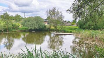 A calm water body with surrounding greenery and a dock.