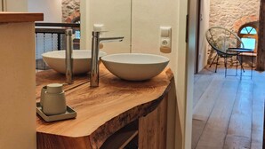 A wooden vanity with two vessel sinks, a small cabinet, and a chair in the background. - Private sauna, 2 fireplaces: Bright flat - last minute (Großharthau)