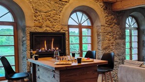 A stone-walled room with a fireplace, wooden bar, and arched windows. - Private sauna, 2 fireplaces: Bright flat - last minute (Großharthau)