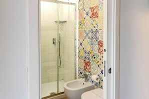 Un baño con ducha, inodoro y bidé.
